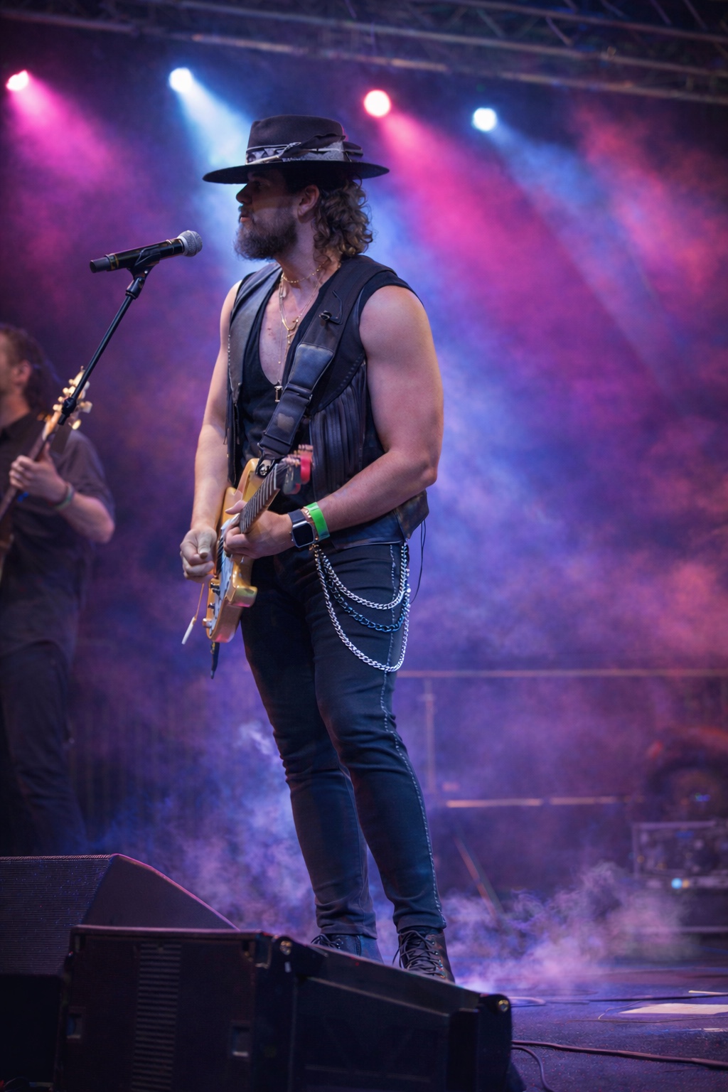 Will Plus performing on electric guitar under colorful concert lights in South Florida