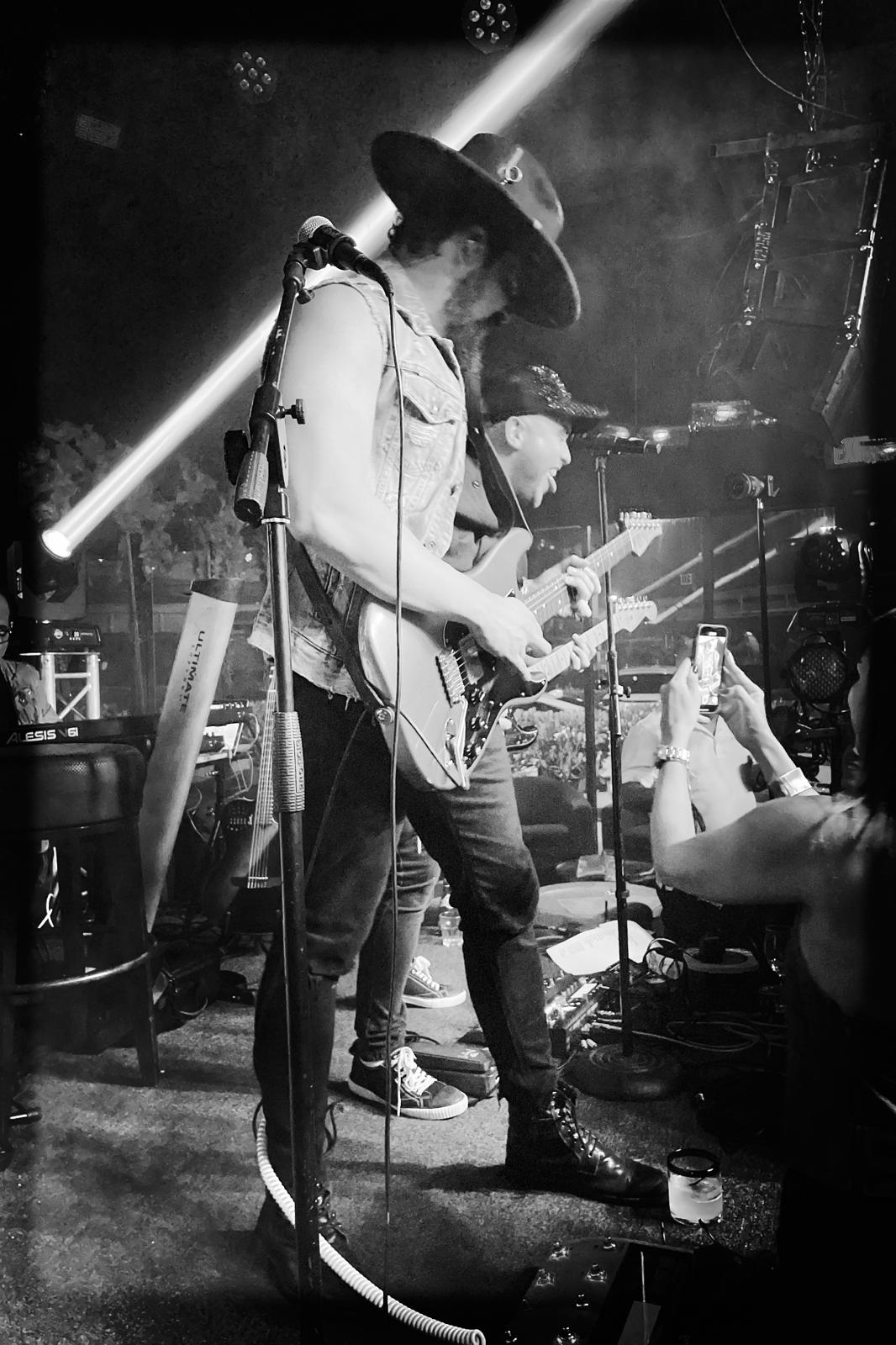 Will Plus playing electric guitar with his band during a live performance