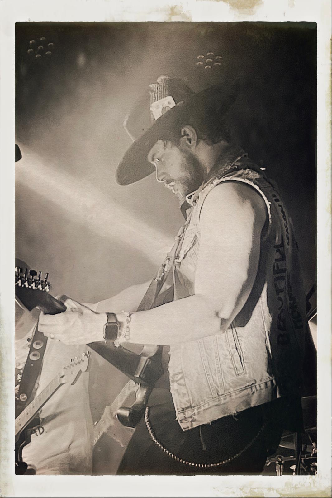 Vintage-style concert portrait of Will Plus playing electric guitar live